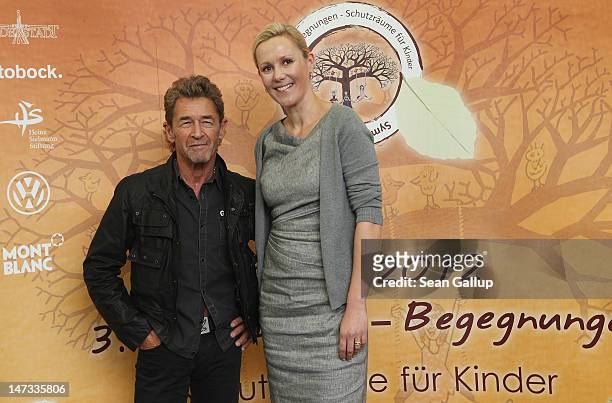 German musician Peter Maffay and former First Lady Bettina Wulff pose after speaking to the media about Maffay's charity project symposium for...