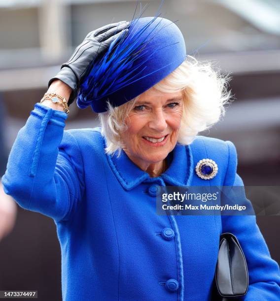 Camilla, Queen Consort holds onto her hat in the wind as she attends the 2023 Commonwealth Day Service at Westminster Abbey on March 13, 2023 in...