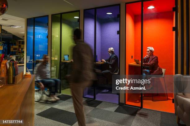 business people walking quickly passing small private colorful offices - small conference room stock pictures, royalty-free photos & images