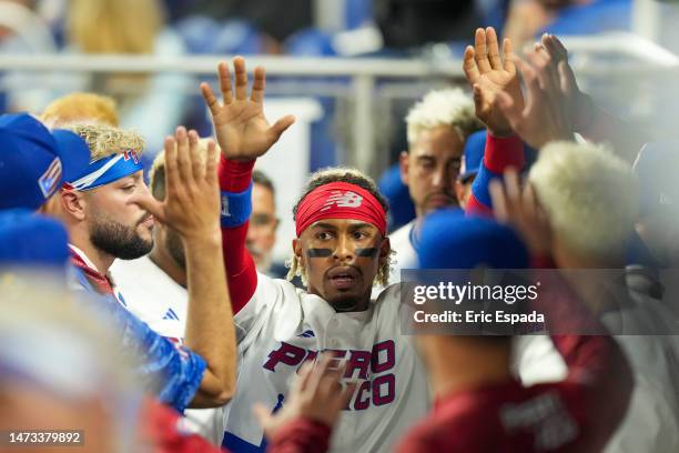 Francisco Lindor of Puerto Rico is congratulated by teammates after scoring on a double hit by Enrique Hernandez in the second inning against Israel...