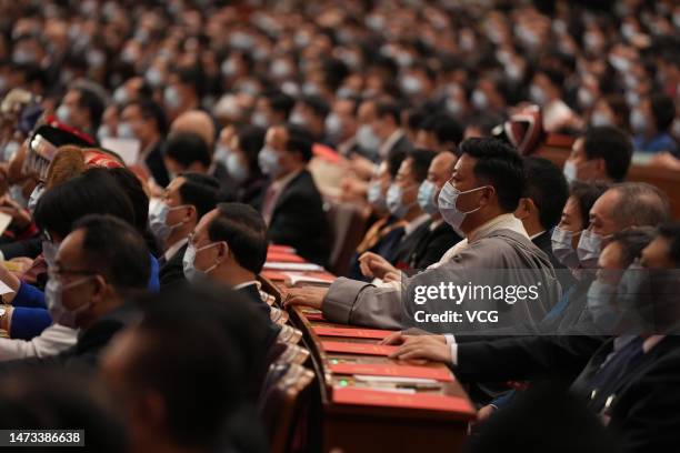 Deputies to the 14th National People's Congress attend the closing meeting of the first session of the 14th National People's Congress at the Great...