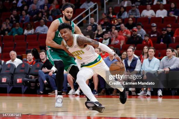 Jalen Green of the Houston Rockets drives past Derrick White of the Boston Celtics during the first half at Toyota Center on March 13, 2023 in...