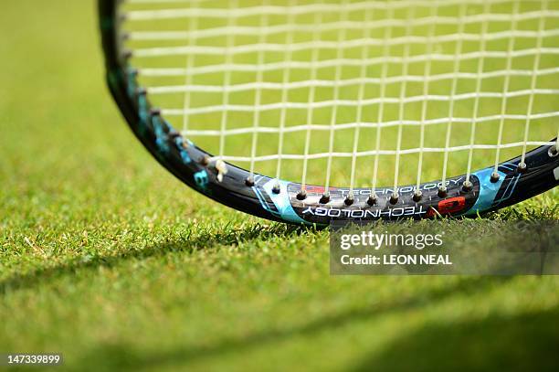 Tennis racket on the grass during the second round women's singles match between China's Zheng Jie and Canada's Aleksandra Wozniak on day four of the...