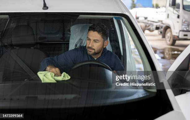 mann arbeitet in einer autowaschanlage und poliert ein fahrzeug - windschutzscheibe innen stock-fotos und bilder