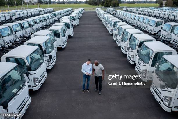 venditore che parla con un cliente interessato all'acquisto di un camion presso una concessionaria di auto - veicolo terrestre commerciale foto e immagini stock