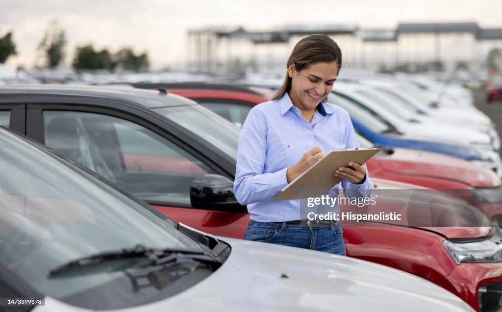 Happy saleswoman working at a car dealership