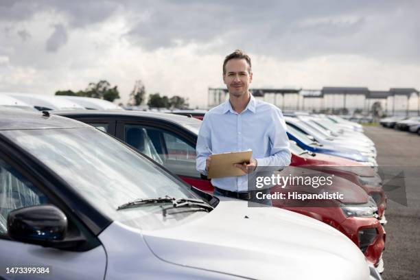 portrait of a salesman working at a car dealership - fleet cars stock pictures, royalty-free photos & images