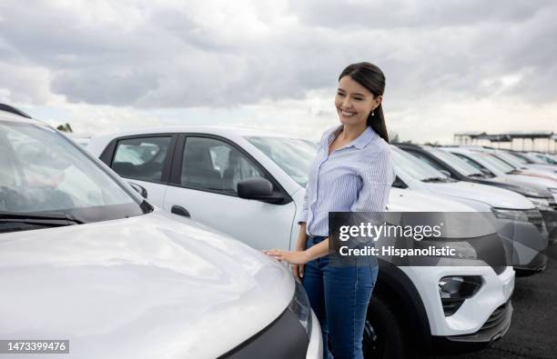 mujer feliz mirando los detalles de un coche en el concesionario - car ownership fotografías e imágenes de stock