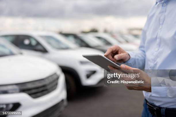 close-up on a car salesperson using a tablet computer - car dealership stockfoto's en -beelden