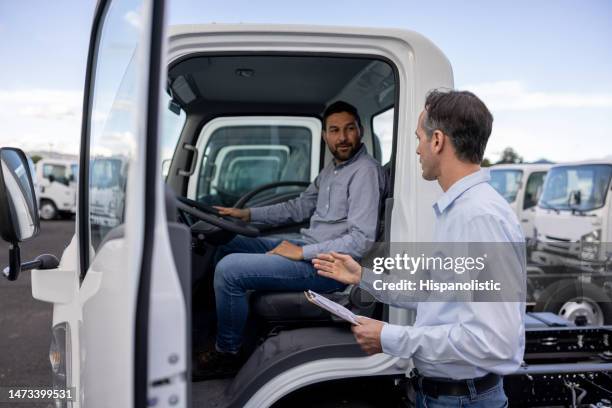 venditore di auto che mostra i camion a un uomo della concessionaria - furgone pickup foto e immagini stock