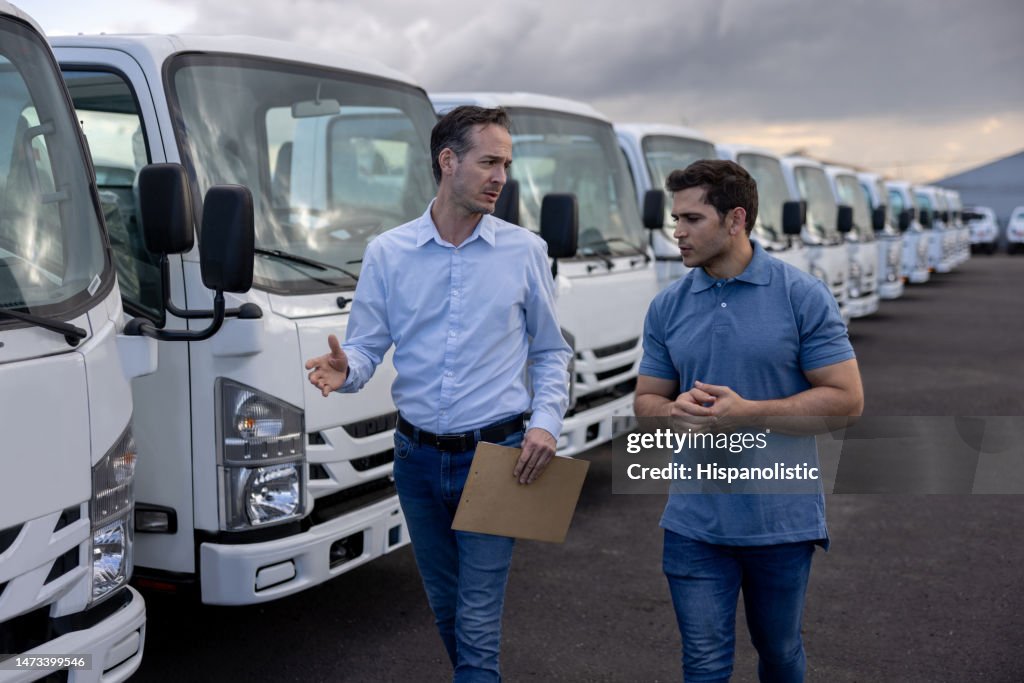Salesman showing trucks to a man at the dealership