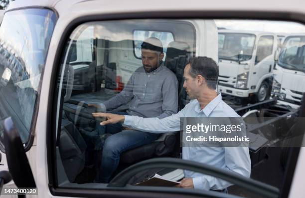 salesman showing trucks to a man at the dealership - fleet cars stock pictures, royalty-free photos & images