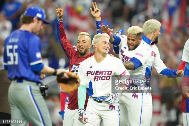 Eddie Rosario of Puerto Rico and Nelson Velazquez celebrate with Enrique Hernandez after he hit a game ending hit against Israel at loanDepot park on...