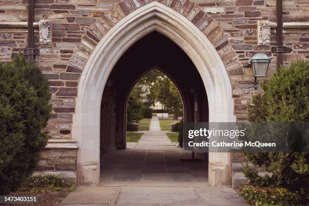 arch tunnel passage on gothic style college campus - college admissions stock pictures, royalty-free photos & images