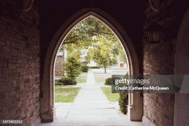 arch tunnel passage on gothic style college campus - college admissions stockfoto's en -beelden