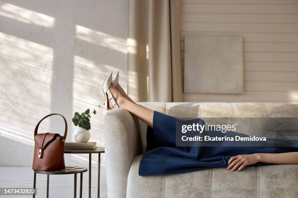 crop woman in elegant dress relaxing on couch - womens footwear stock pictures, royalty-free photos & images