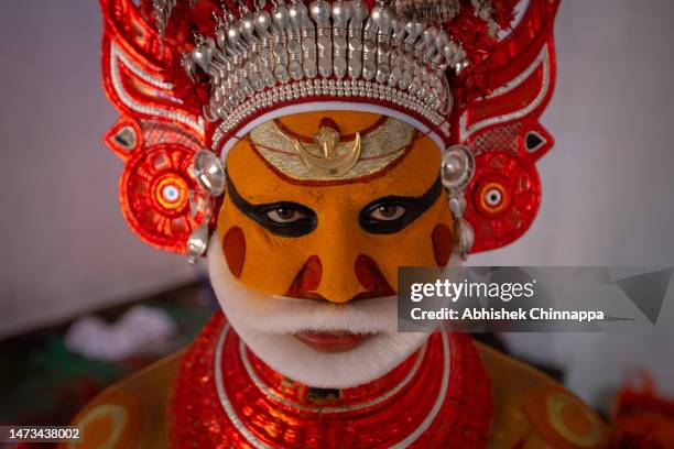 Man dressed in the likeness of the Hindu deity Muthappan waits to perform during the Theyyam ritualistic dance festival on March 13, 2023 in...