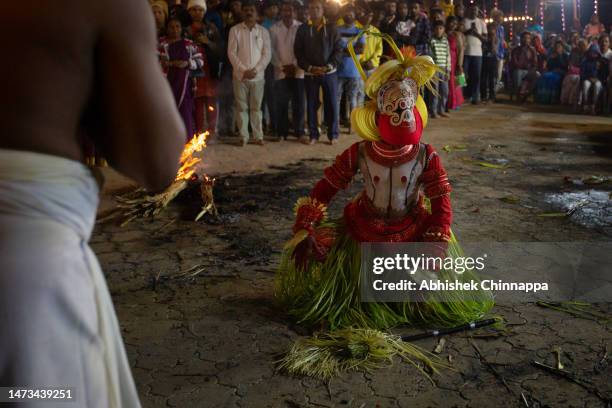 Man dressed in the likeness of the Hindu deity Pottan performs during the Theyyam ritualistic dance festival on March 14, 2023 in Somwarpet, India....