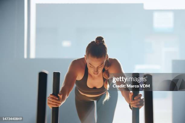 fitness, health and woman with a sled in the gym doing strength, endurance and running workout. motivation, sports and female athlete doing intense cardio exercise with prowler push in a sport center - center athlete stockfoto's en -beelden