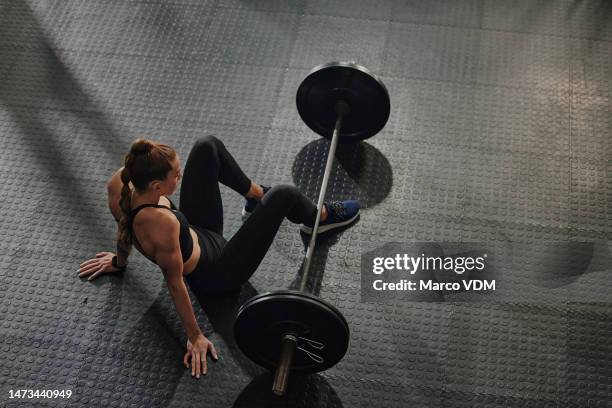 fitness, bodybuilding and woman weightlifter taking a break in the gym after a workout from above. exercise, training and rest with a strong female athlete or bodybuilder sitting on the floor - sitting on ground stock pictures, royalty-free photos & images