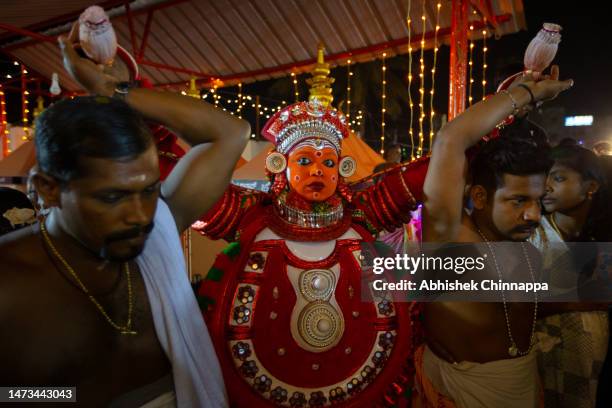Man dressed in the likeness of the Hindu deity Kandakarnan performs during the Theyyam ritualistic dance festival on March 13, 2023 in Somwarpet,...