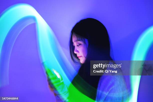young asian woman using a smartphone on the holographic background. concept technology - smartphone hologram stock pictures, royalty-free photos & images