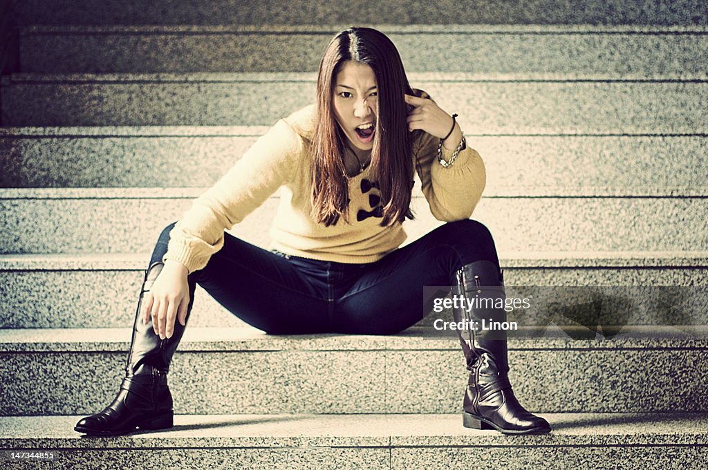 Young woman sitting on stair