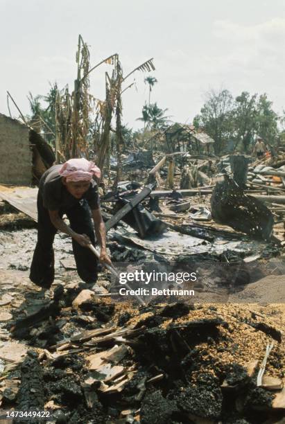 Villager in Ben Muong, South Vietnam, salvages items in ruins after government troops recaptured the area, March 14th 1975.