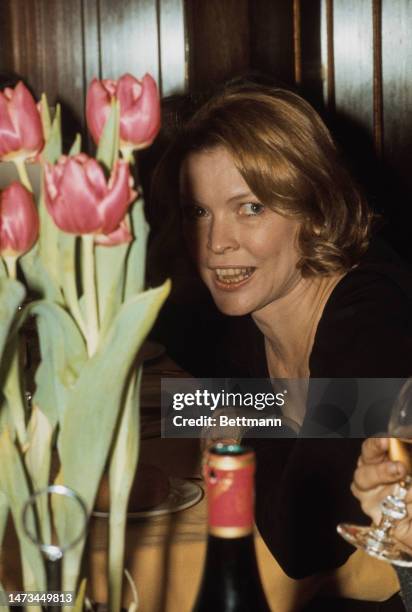 Close-up of actress Ellen Burstyn sitting near a pot of tulips at a party in New York on March 13th, 1975.