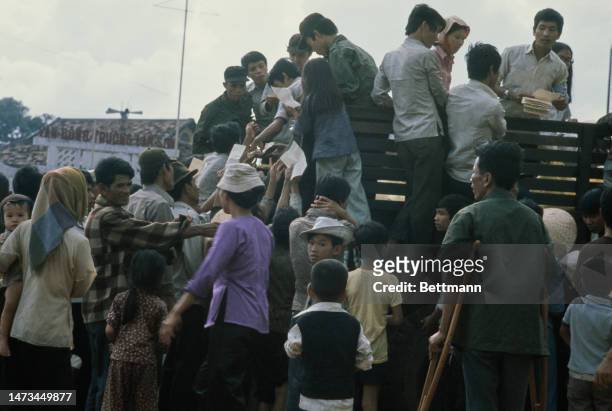 Refugees at Vung Tau refugee camp, South Vietnam, are given food and information leaflets on April 11th, 1975.