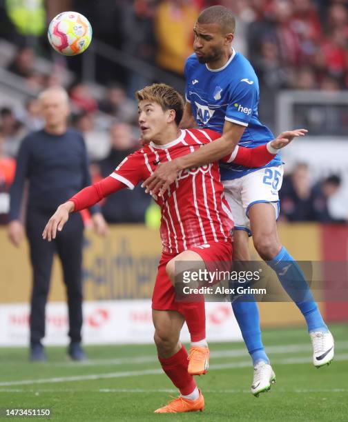 Ritsu Doan of Freiburg is challenged by Kevin Akpoguma of Hoffenheim during the Bundesliga match between Sport-Club Freiburg and TSG Hoffenheim at...