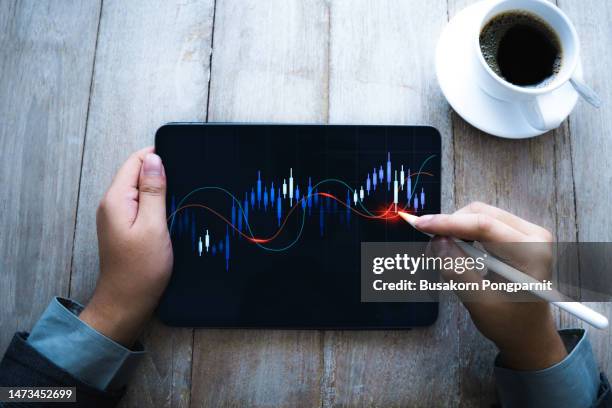 a business person tracking the technical movement of a stock chart with technology digital tablet. - exchanging stock pictures, royalty-free photos & images