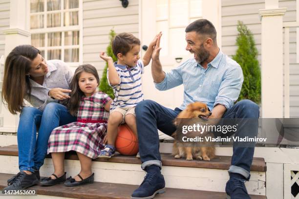 a family of four on the front steps - home sweet home dog stock pictures, royalty-free photos & images