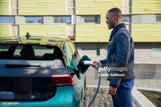 charging my electric car - hybrid car charging stock pictures, royalty-free photos & images