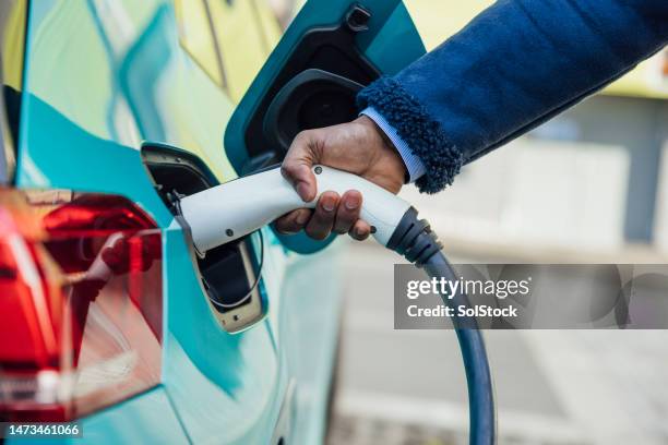 charging electric car - electric vehicle stock pictures, royalty-free photos & images