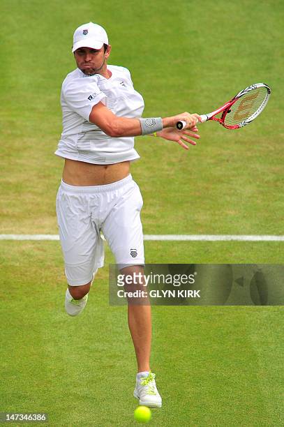 Player Mardy Fish plays a forehand shot during his second round men's singles match against Britain's James Ward on day four of the 2012 Wimbledon...