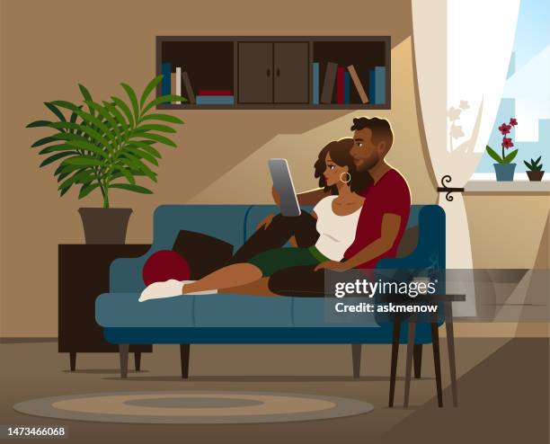 couple on a sofa - hispanic man computer stock illustrations