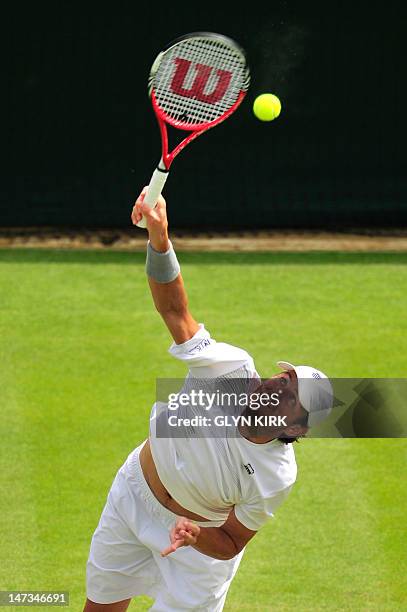 Player Mardy Fish serves during his second round men's singles match against Britain's James Ward on day four of the 2012 Wimbledon Championships...