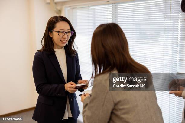 business people changing business card - business cards on table stock pictures, royalty-free photos & images