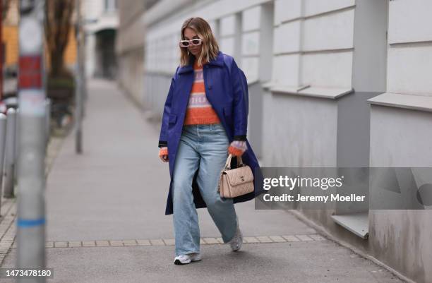 Karin Teigl seen wearing Loewe light pink sunglasses, gold / silver jewelry, Miu Miu pink / orange logo knit sweater / pullover, Mother Denim light...