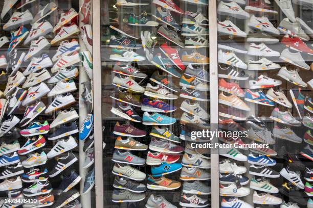 vitrine de dizaines de chaussures d’entraînement - magasin de chaussures photos et images de collection