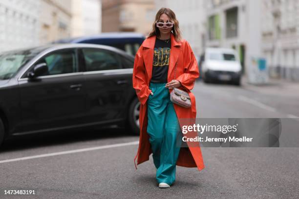 Karin Teigl seen wearing Loewe light pink sunglasses, gold / silver jewelry, Samsoe Samsoe turquoise / blue leather pants, Chanel colorful fabric...