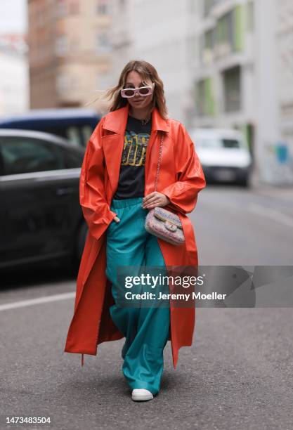 Karin Teigl seen wearing Loewe light pink sunglasses, gold / silver jewelry, Samsoe Samsoe turquoise / blue leather pants, Chanel colorful fabric...