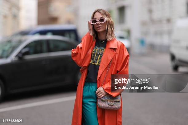 Karin Teigl seen wearing Loewe light pink sunglasses, gold / silver jewelry, Samsoe Samsoe turquoise / blue leather pants, Chanel colorful fabric...