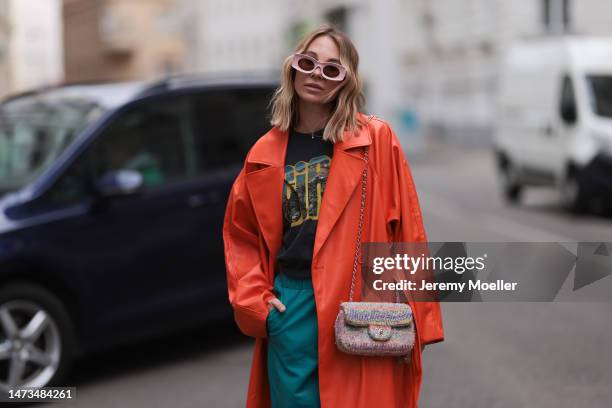 Karin Teigl seen wearing Loewe light pink sunglasses, gold / silver jewelry, Samsoe Samsoe turquoise / blue leather pants, Chanel colorful fabric...