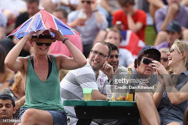 Tennis spectators watch the Gentlemen's Singles second round match from the lawn between Andy Murray of Great Britain and Ivo Karlovic of Croatia on...