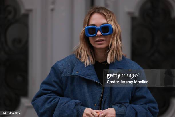 Karin Teigl seen wearing Loewe blue sunglasses, Louis Vuitton dark blue denim logo print pattern jacket, gold / silver jewelry, Saint Laurent black...