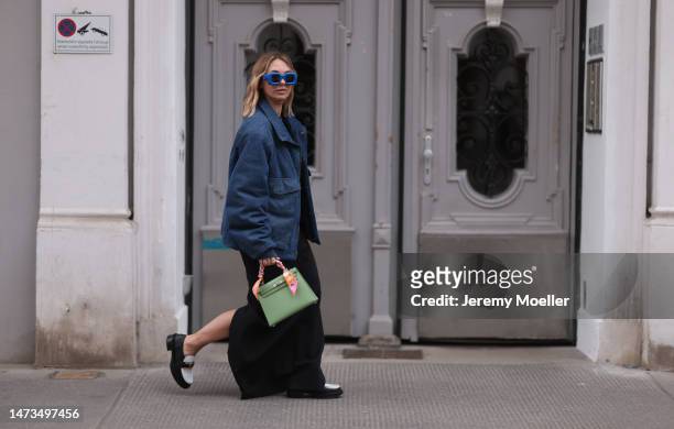 Karin Teigl seen wearing Loewe blue sunglasses, Louis Vuitton dark blue denim logo print pattern jacket, gold / silver jewelry, Saint Laurent black...