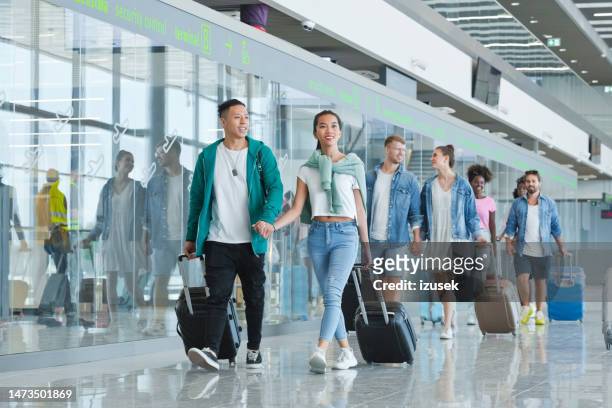 people with luggage at airport - airport crowd stock pictures, royalty-free photos & images