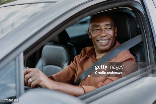 portrait of a mature male driver in the car - taxi driver stock pictures, royalty-free photos & images
